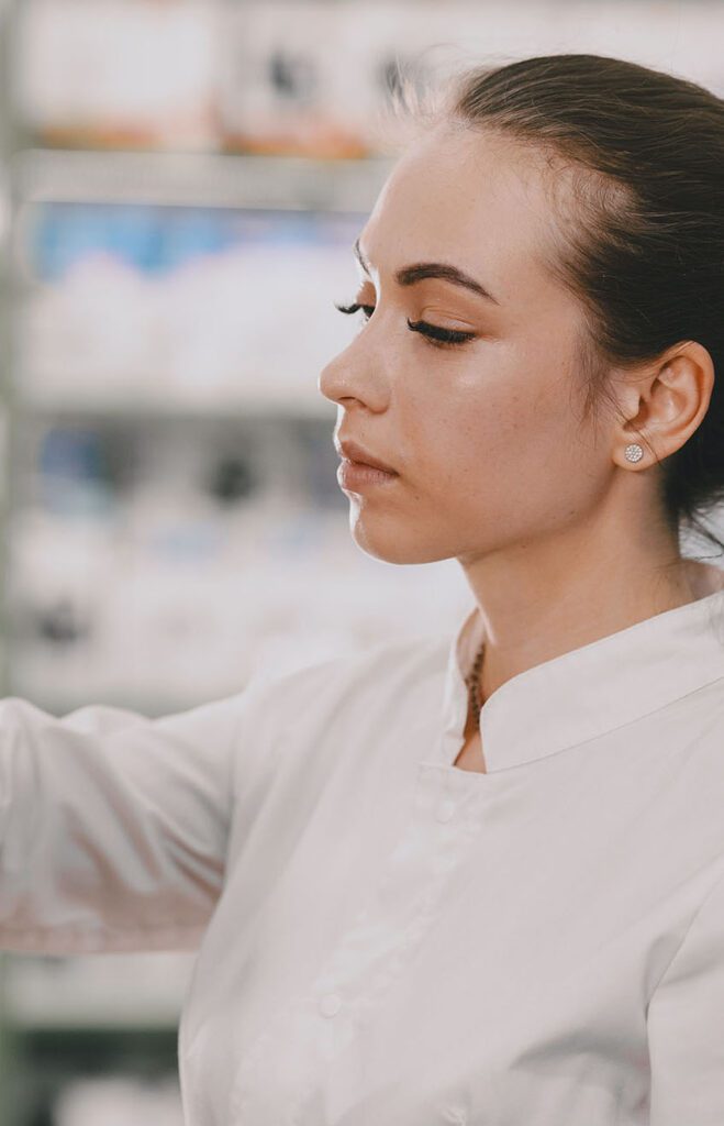 Pharmacist sorting products on shelf